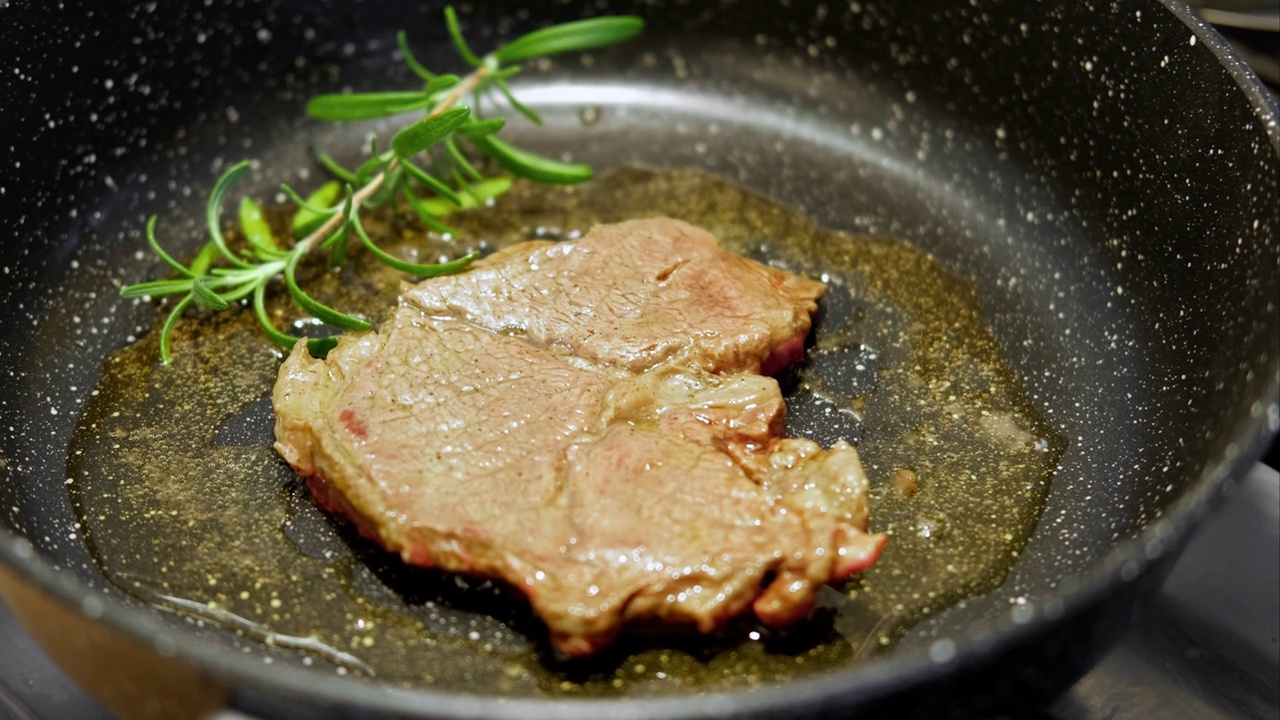 用香草黄油、胡椒和迷迭香煎牛肉片。煎肉排。特写镜头。煎牛眼肋排。菲力牛排。制作原味安格斯肋眼。食物配方背景视频素材