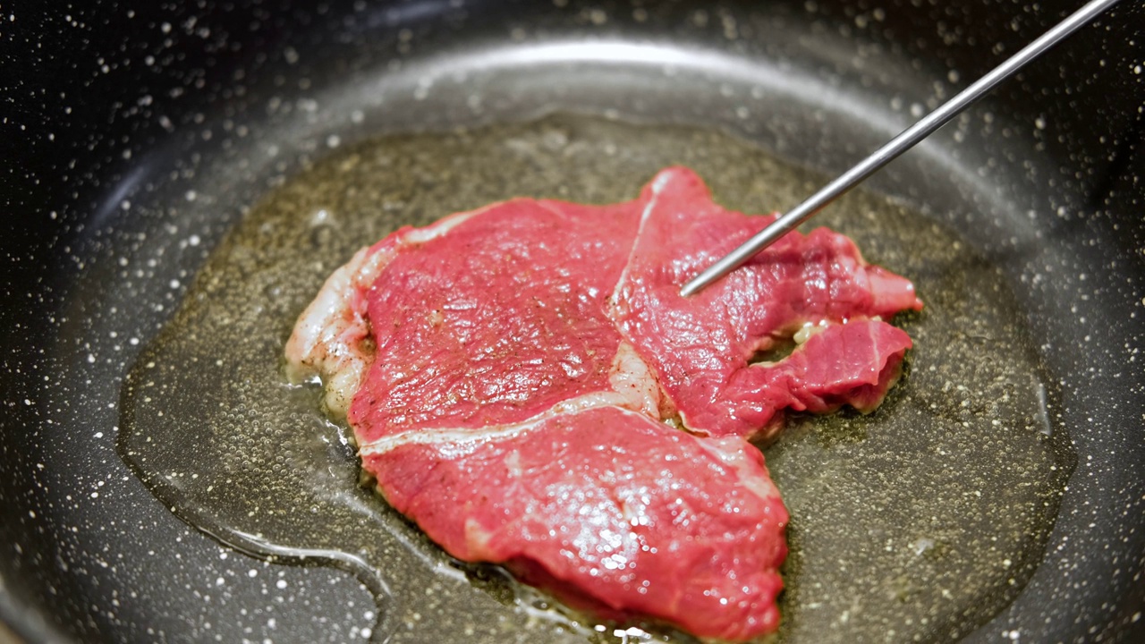 用香草黄油、胡椒和迷迭香煎牛肉片。煎肉排。特写镜头。煎牛眼肋排。菲力牛排。制作原味安格斯肋眼。食物配方背景视频素材