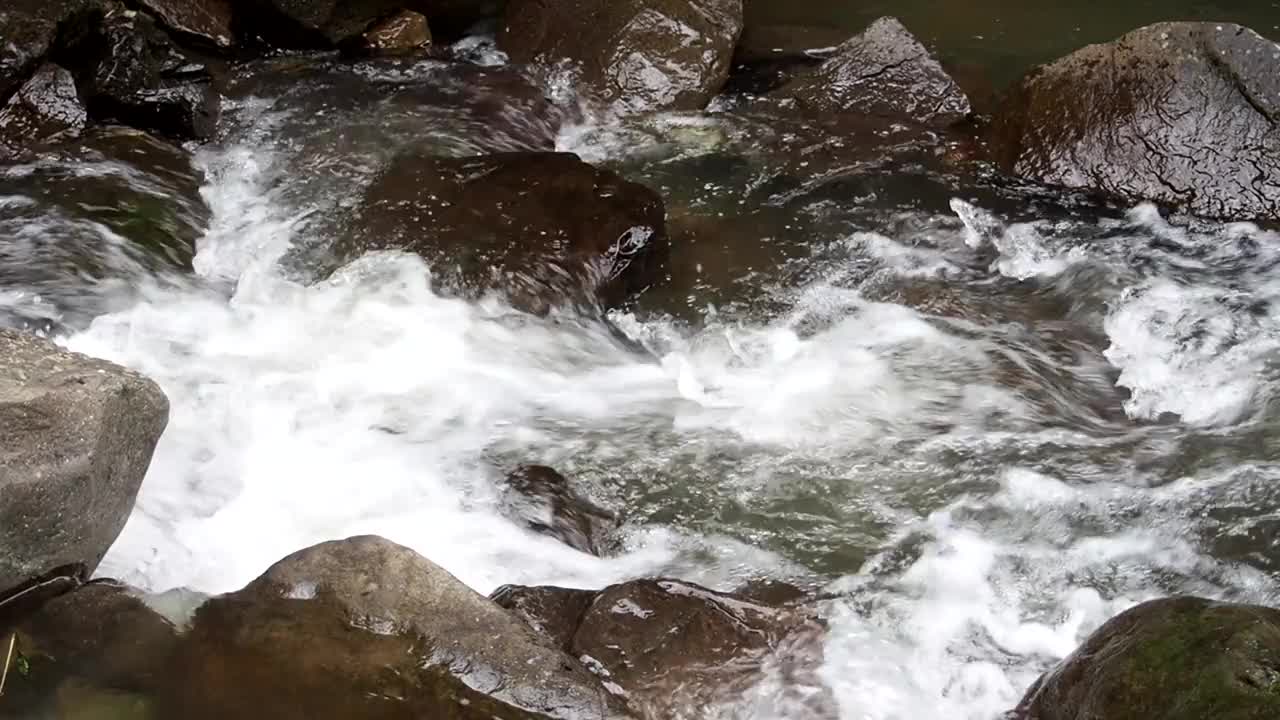 瀑布。湍急河流的门槛。一股冰冷的水流拍打着棕色的巨石。水倒在岩石上。水射流。在户外。浇水和洗手的地方。视频下载