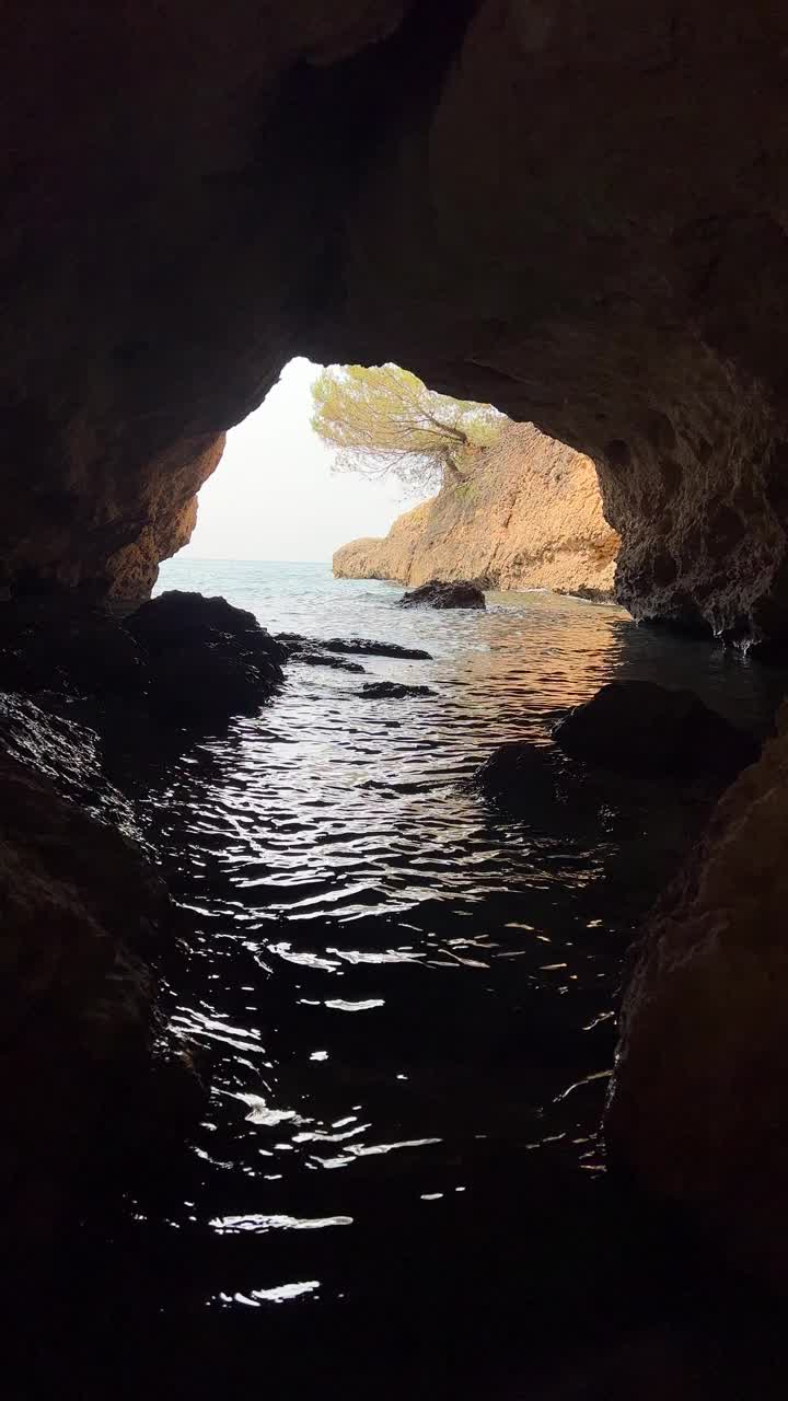 洞穴石窟在海上，在岩石海岸的看法，垂直视频。视频素材