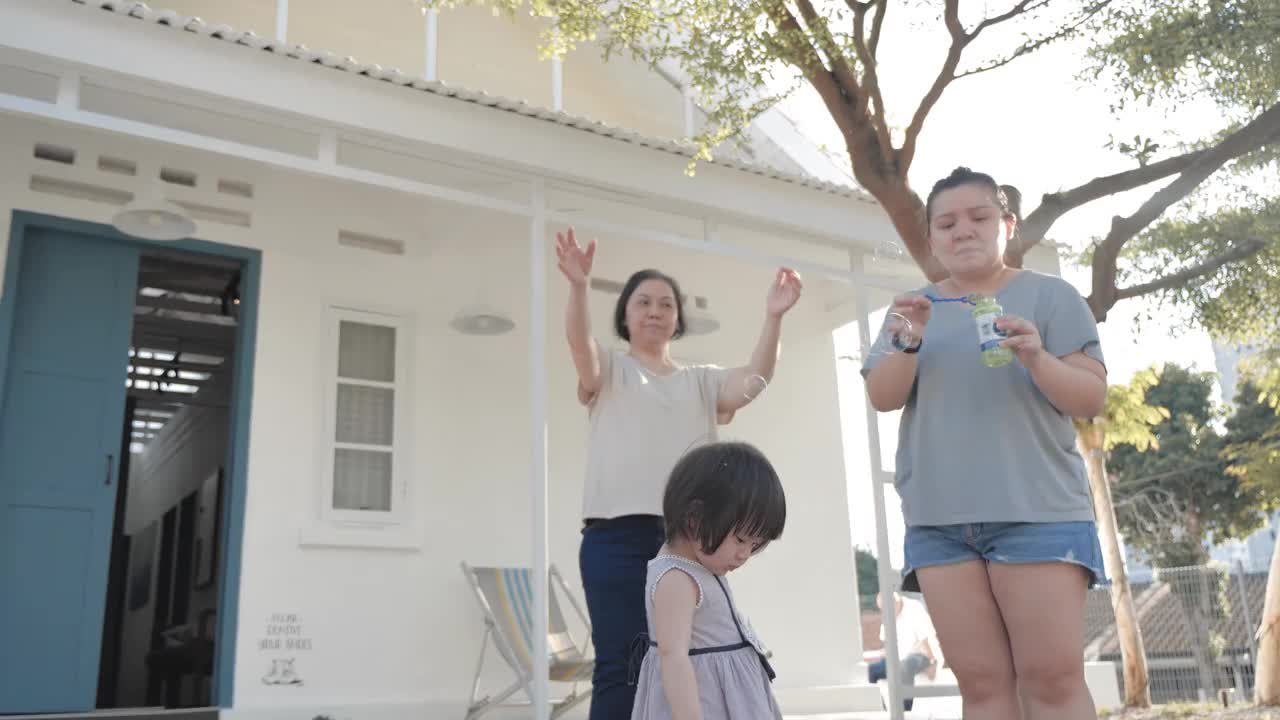 亚洲奶奶和妈妈和孙女一起吹泡泡视频素材