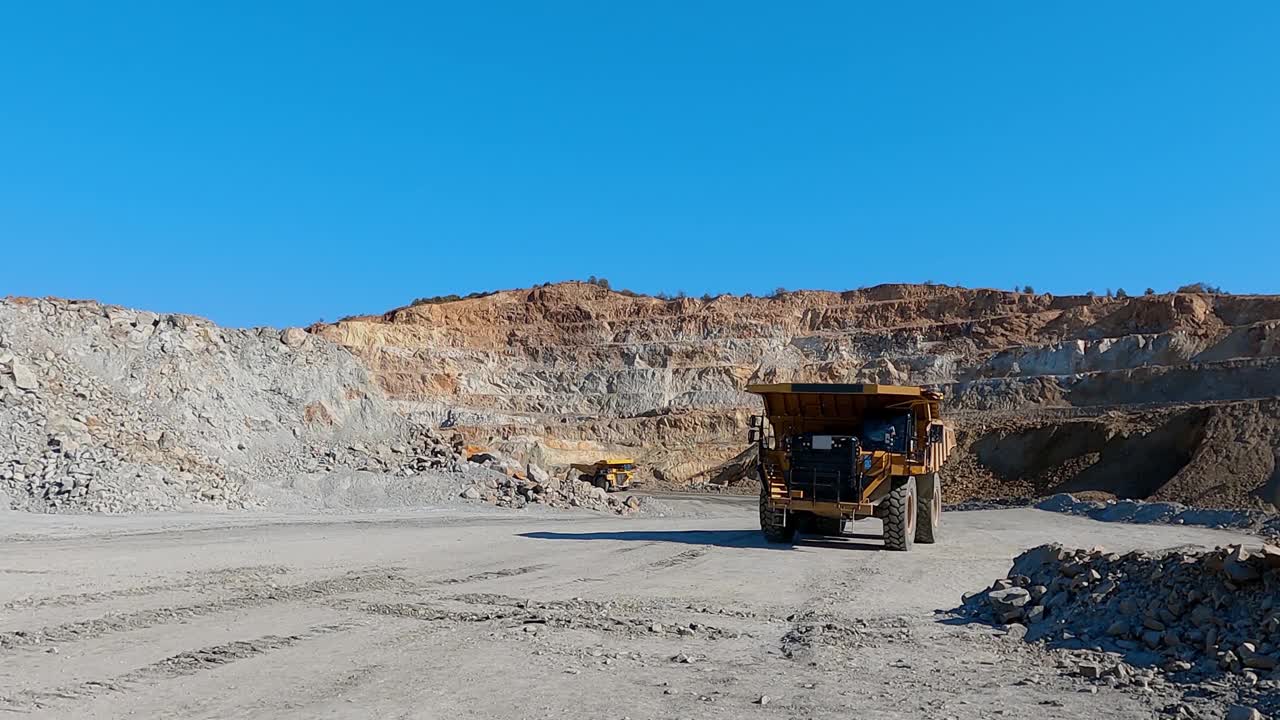 重型矿用自卸卡车沿着露天露天矿坑行驶，慢动作视频素材