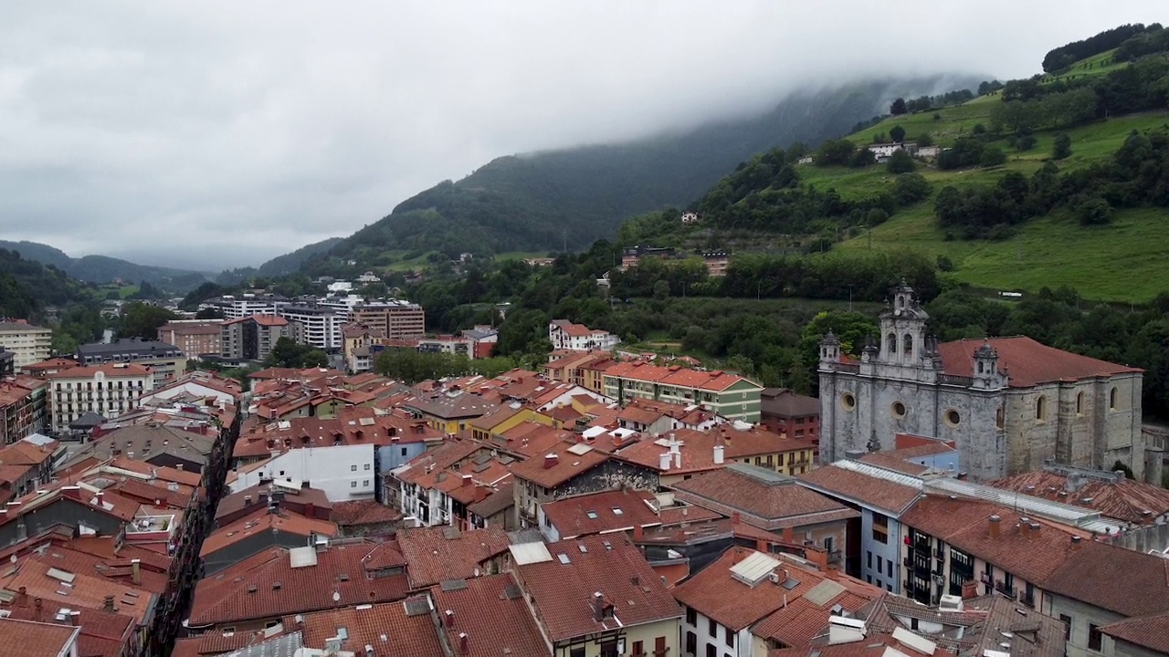 西班牙巴斯克地区，托洛萨老城区的屋顶景观，背景是美丽的多云天空和绿色的山脉视频下载