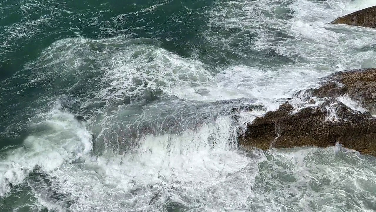 强大的蓝色海浪拍打着岩石。视频素材