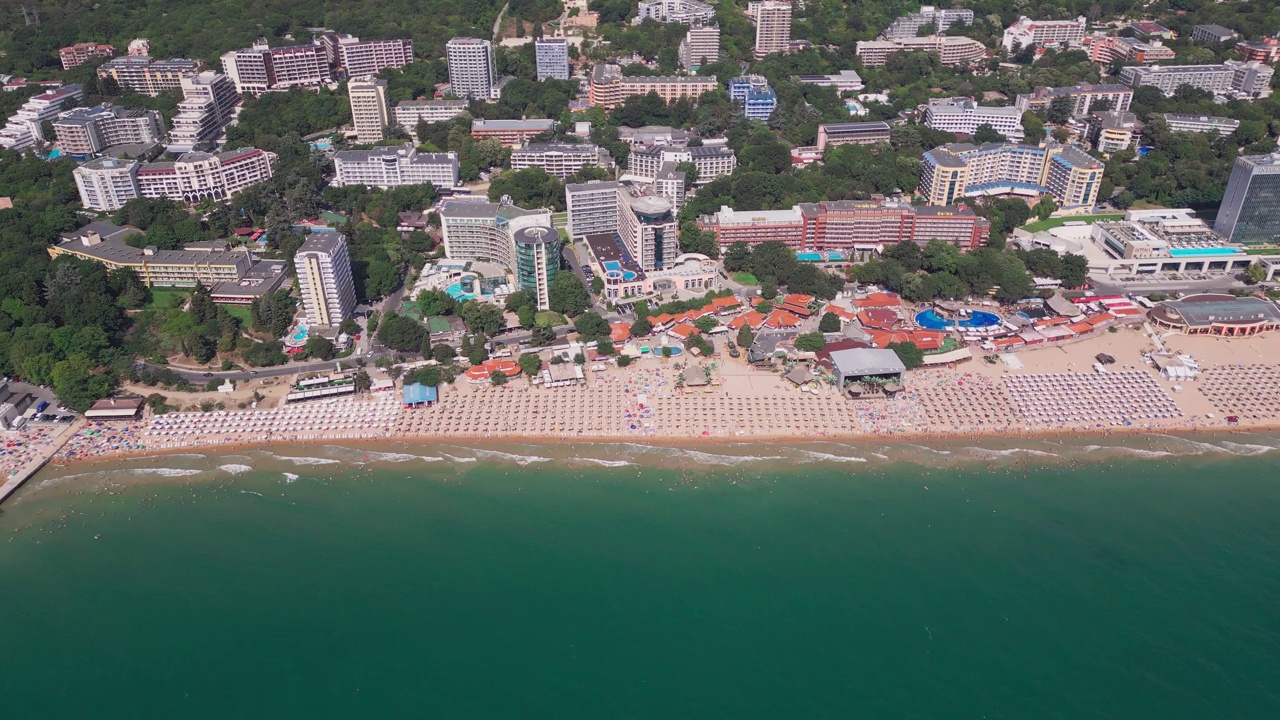 夏季保加利亚黑海海岸的鸟瞰图:一系列的酒店、游泳池和享受大海的人群。视频素材