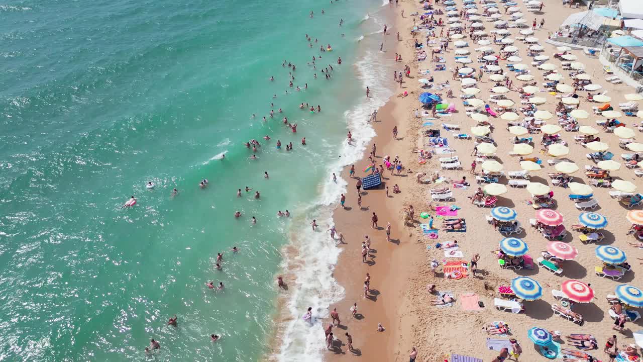 夏季保加利亚黑海海岸的鸟瞰图:一系列的酒店、游泳池和享受大海的人群。视频素材