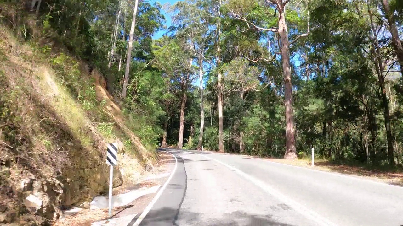 在澳大利亚昆士兰州黄金海岸斯普林布鲁克乡村公路上行驶的风景片段视频素材