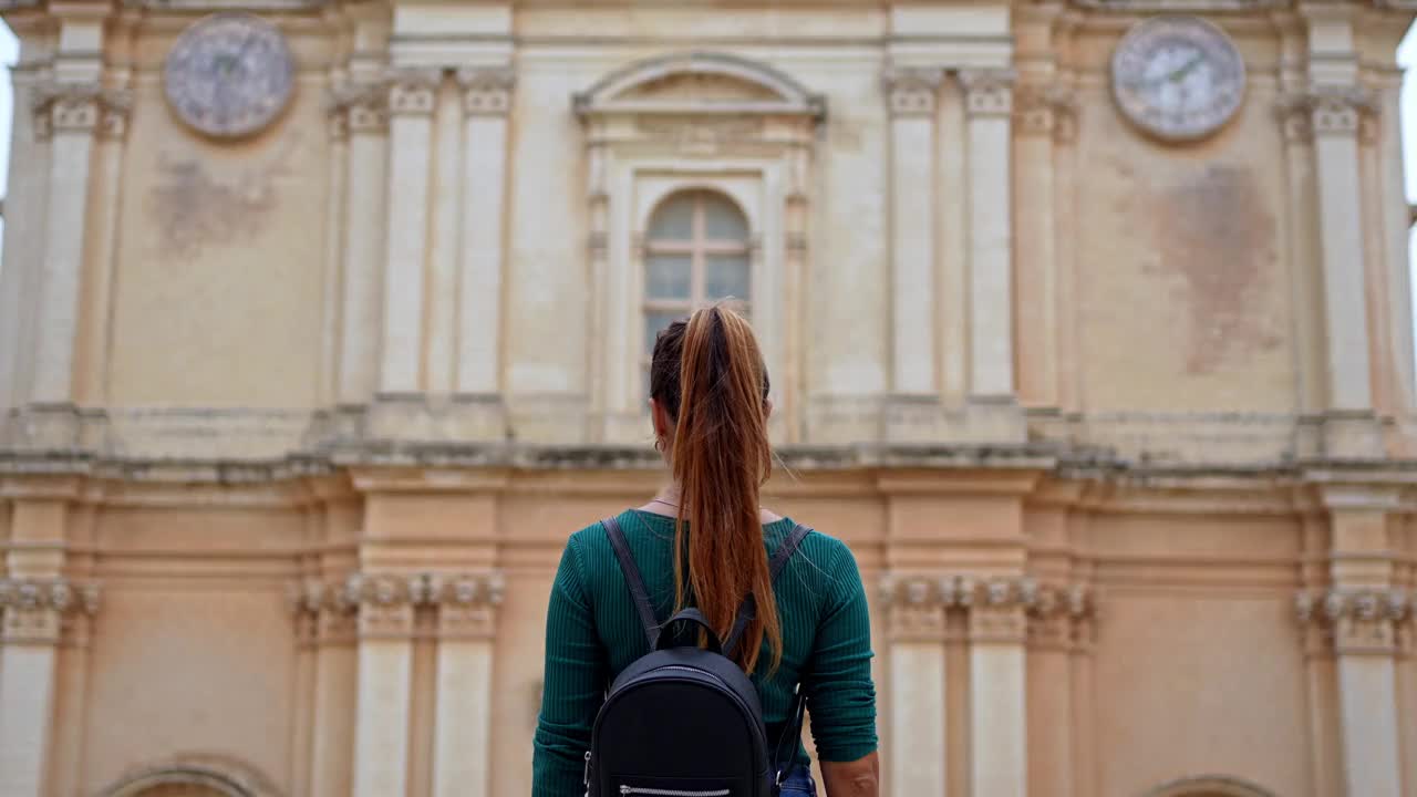 一名年轻女子在欣赏马耳他姆迪纳圣保罗大教堂的景色视频素材