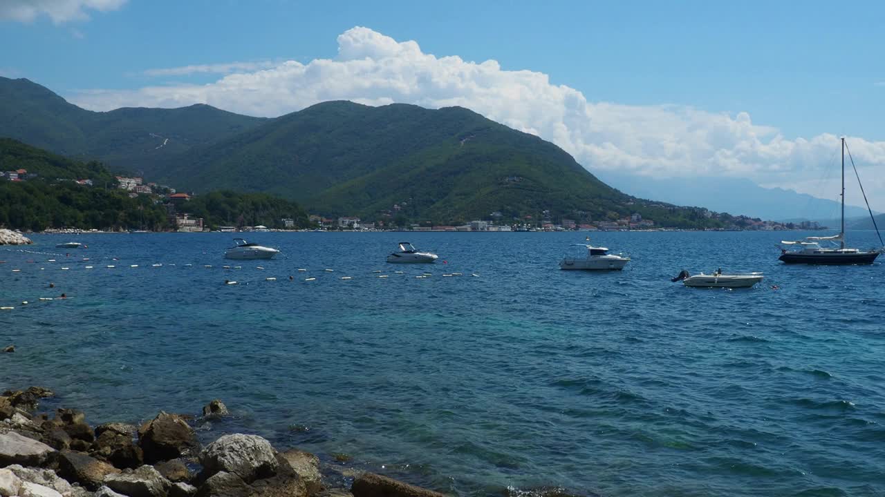 海上度假旅行。小船漂浮在亚得里亚海上。地中海旅游业务。帆船和山脉。水波纹。阳光明媚的天气。钓鱼放松。蓝绿色的波。视频素材