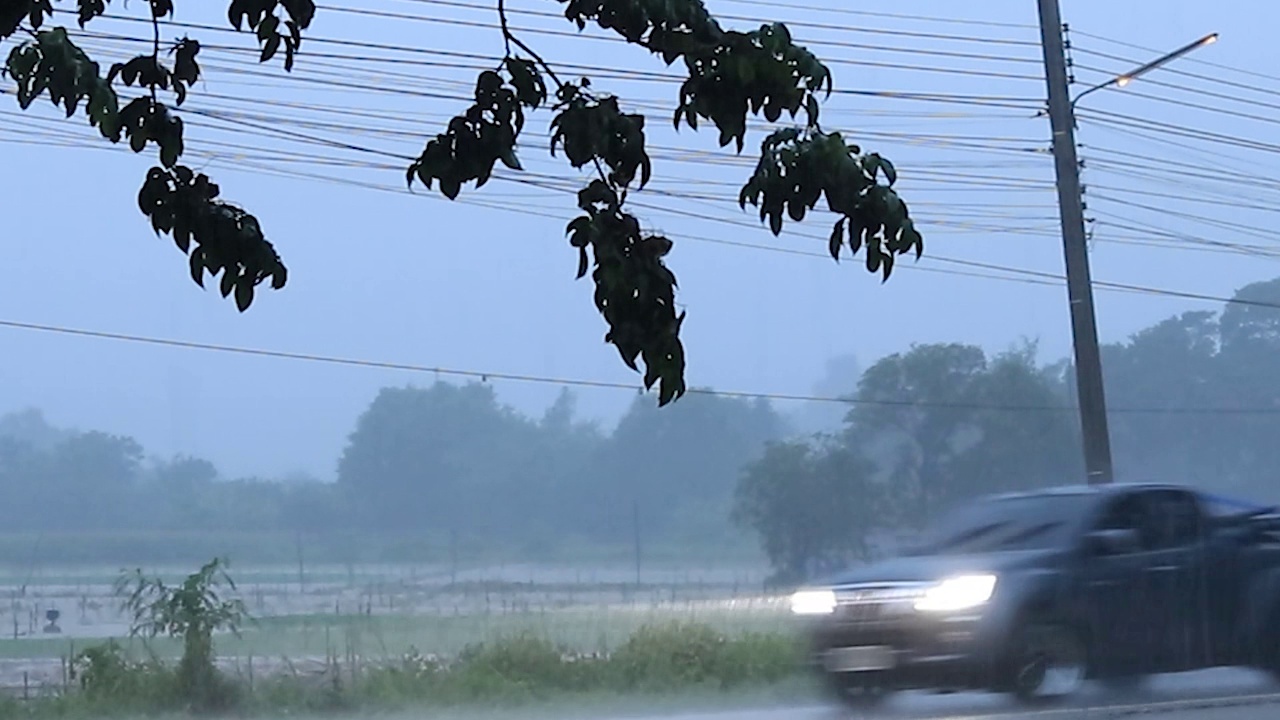 晚上暴风雨带来的大雨使得汽车行驶在道路上，使得交通变得危险，在泰国的农村道路上需要小心。视频下载