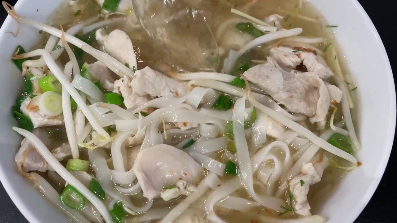 Pho Ga，越南鸡肉面汤。搅拌美味，热的亚洲食物，汤汁在碗里。视频下载