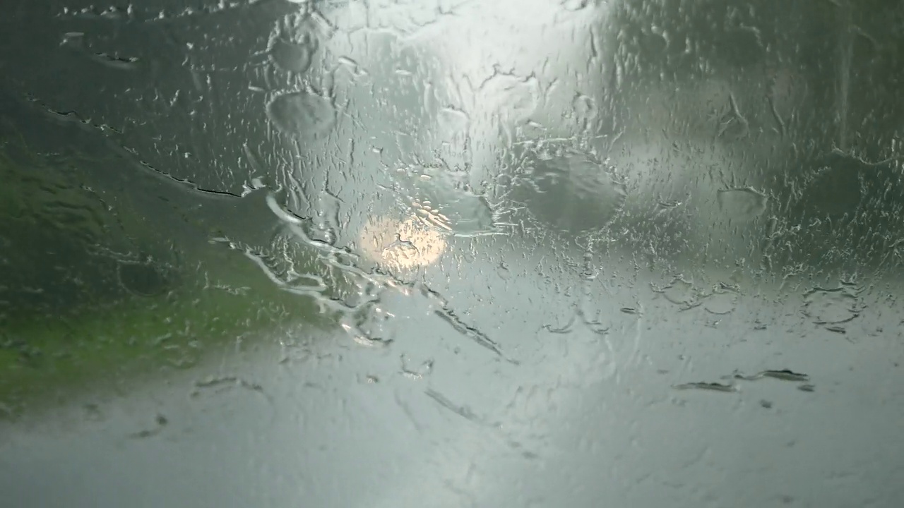 在暴雨或倾盆大雨中开车。前挡风玻璃上的雨滴和汽车雨刷。视频素材