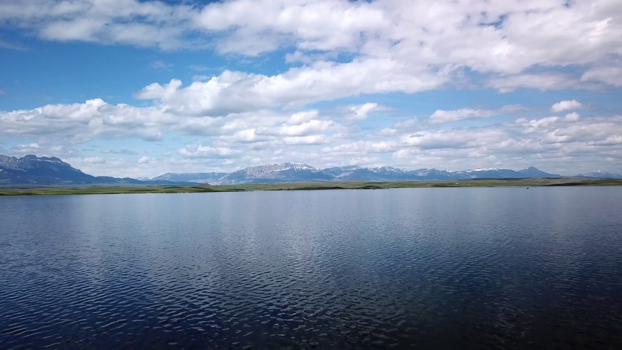 空中拍摄的湖泊附近的山脉对天空，无人机上升后在自然景观-比林斯，蒙大拿州视频素材