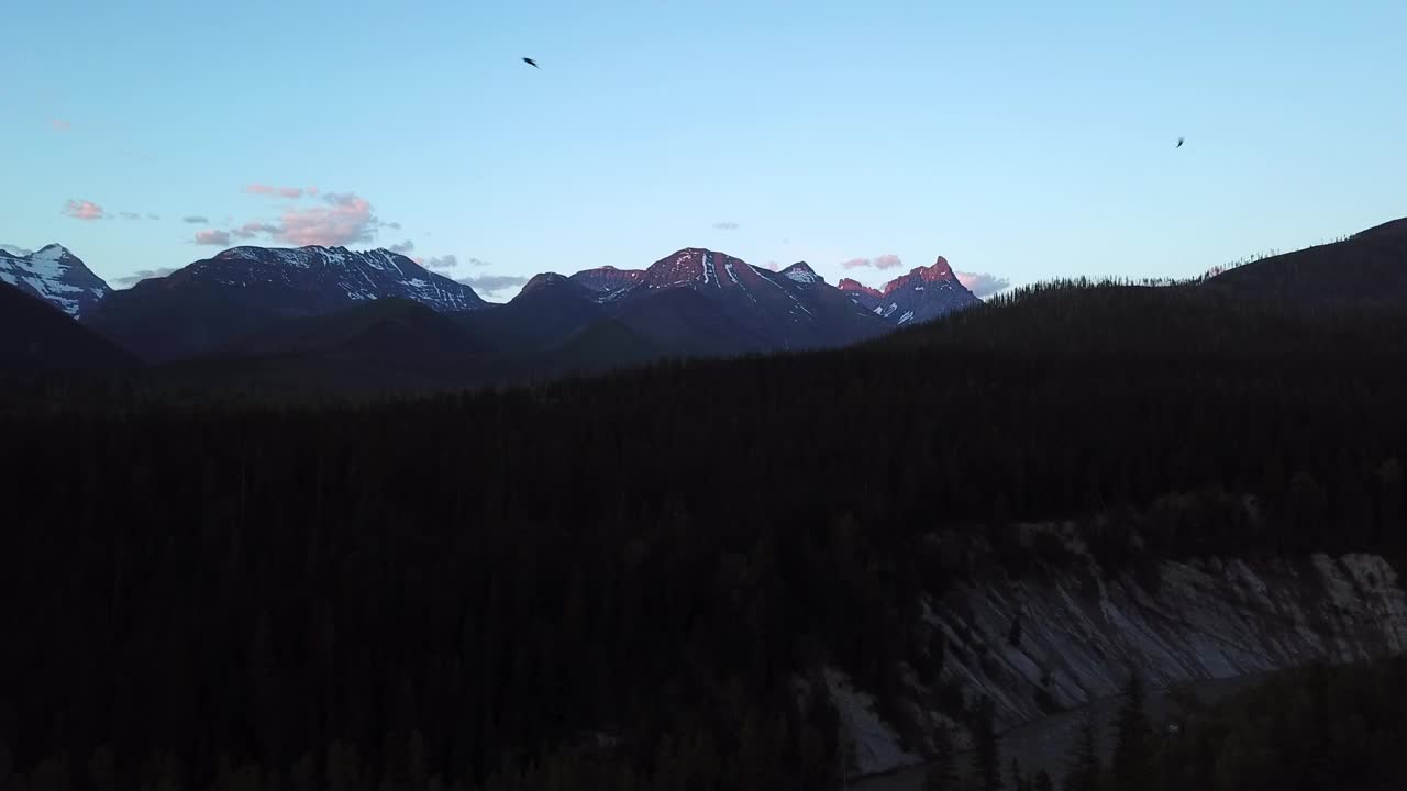 空中平移拍摄的河流在树木之间的剪影山，无人机飞越自然景观对天空在黄昏-利比，蒙大拿州视频素材