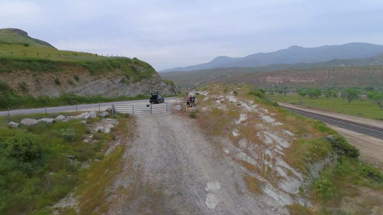 在靠近河流的道路上，人们乘坐汽车的航拍照片，无人机在背对天空的景观上向后上升——加州贝克斯菲尔德视频素材