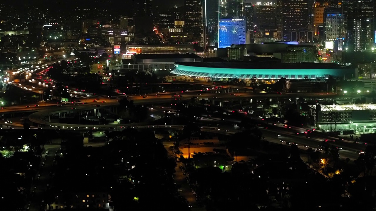 夜间，在灯火通明的城市里，车辆在桥上行驶的空中倾斜镜头——洛杉矶，加利福尼亚视频素材