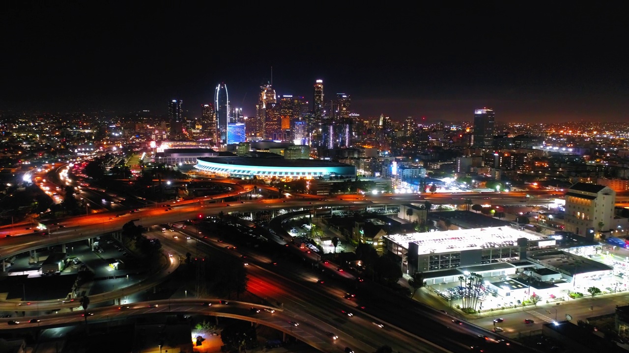 航拍下降拍摄的车辆在高架道路上移动在照明城市对天空在夜晚-洛杉矶，加利福尼亚视频素材