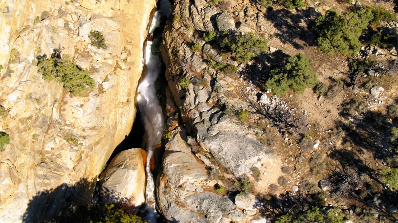 空中俯瞰瀑布在森林中的岩层，无人机飞越景观-主教，加州视频素材