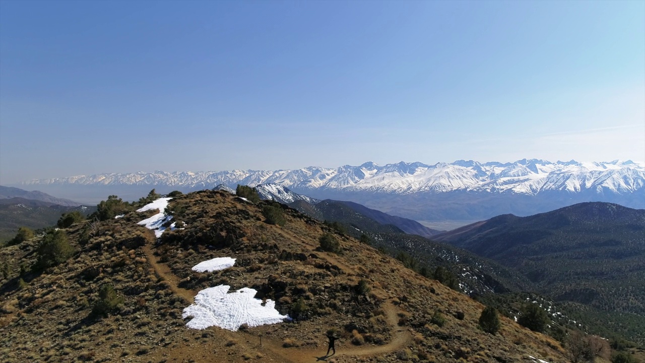 空中拍摄的风景雪山对天空，无人机在自然景观上向后飞行-毕夏普，加州视频素材