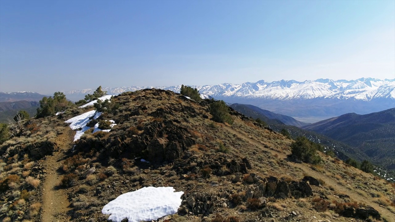 空中拍摄的风景雪山对天空，无人机在自然景观上向后飞行-毕夏普，加利福尼亚视频素材