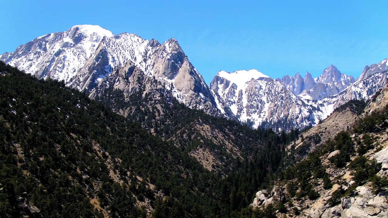 空中拍摄的风景雪山蓝天，无人机上升在森林-主教，加州视频素材