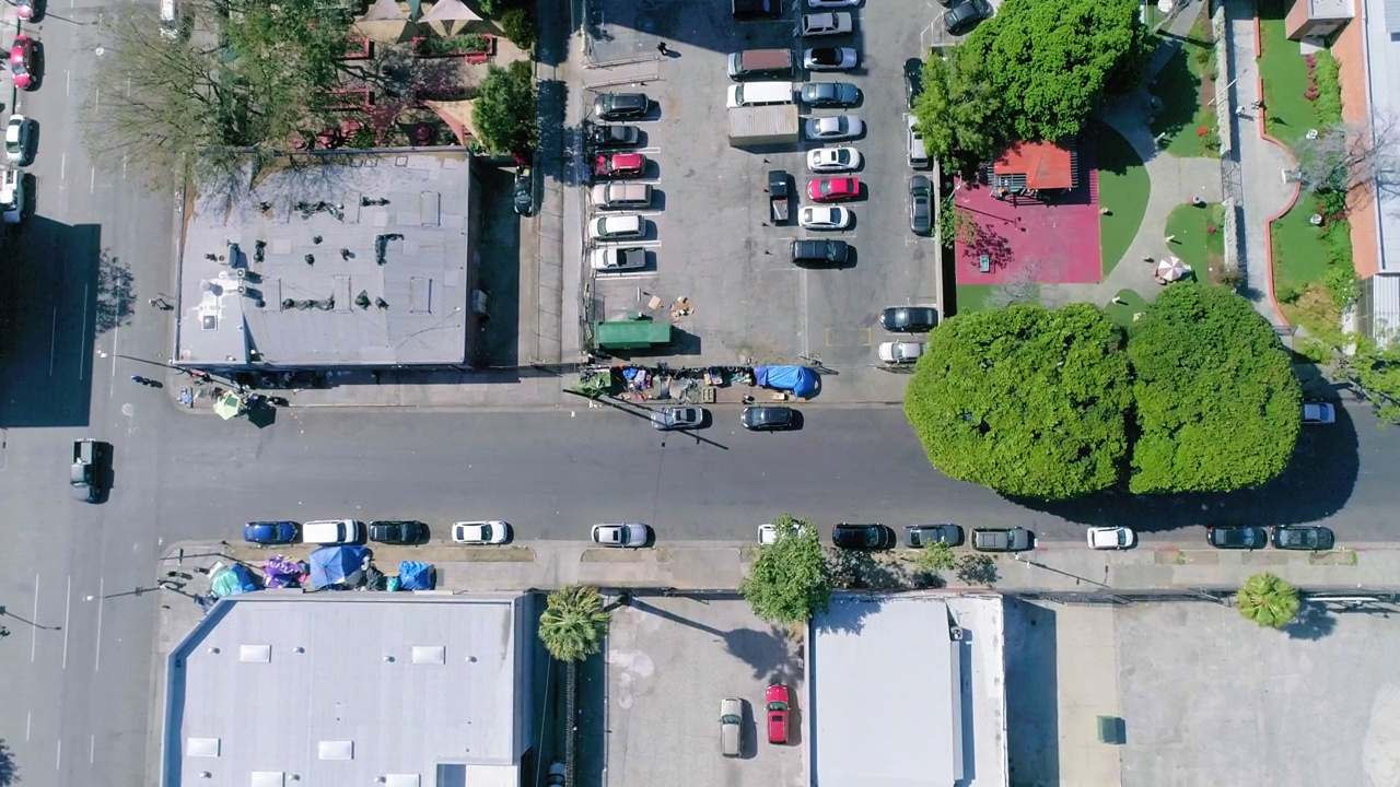 在阳光明媚的日子里，加州洛杉矶，街道上住宅建筑中的车辆鸟瞰图视频素材