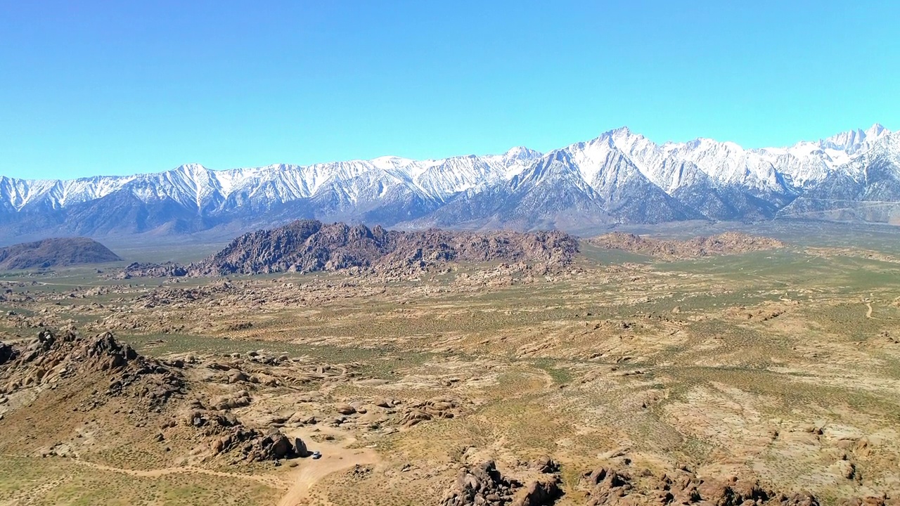 空中拍摄的岩层和雪山对天空，无人机降落在景观-主教，加州视频素材