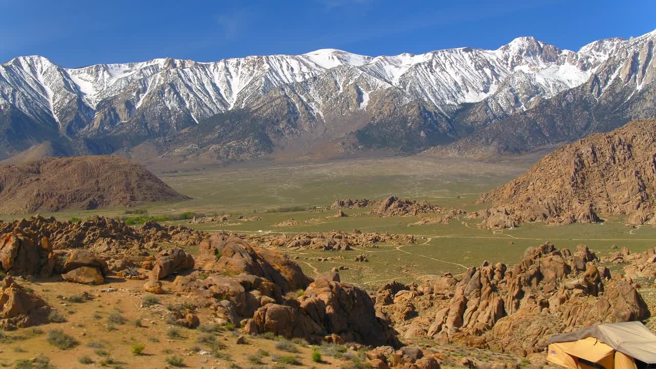 航拍:在阳光明媚的日子里，红岩峡谷州立公园，无人机在白雪皑皑的山脉附近的岩石上对着蓝天进行平移视频素材