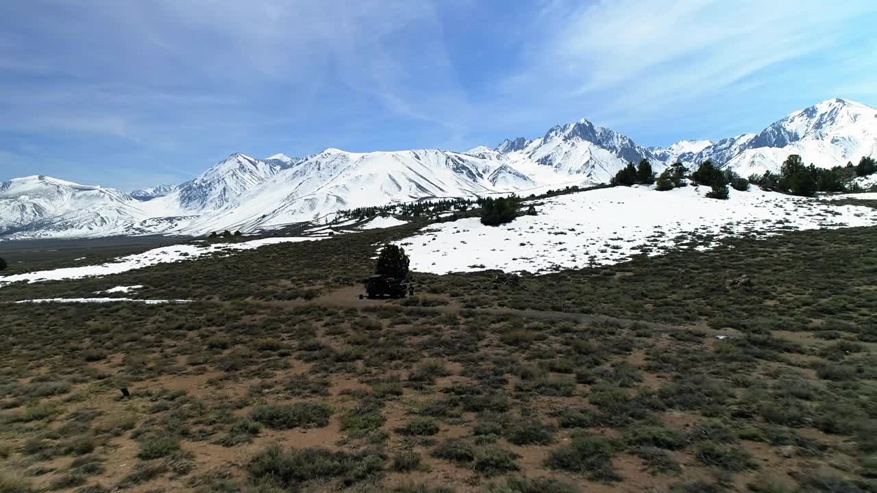 空中向后拍摄的植物和树木与雪附近的山脉对天空在阳光明媚的日子-猛犸湖，加利福尼亚视频素材