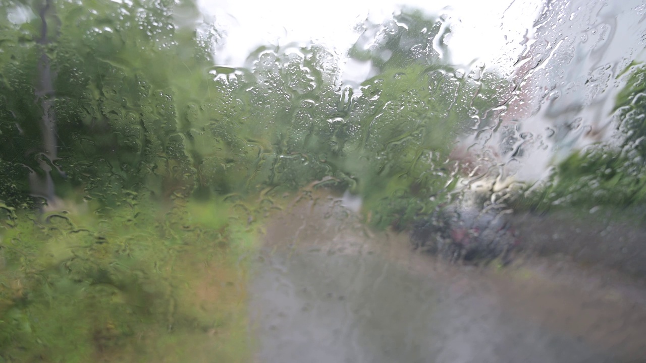 雨滴落在窗户上，夏秋的雨天，汽车挡风玻璃上的雨水视频下载