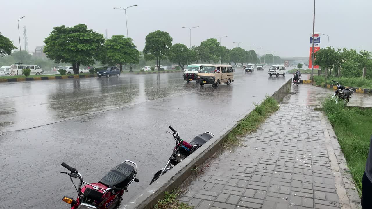 车辆在大雨中行驶，水花飞溅。视频素材