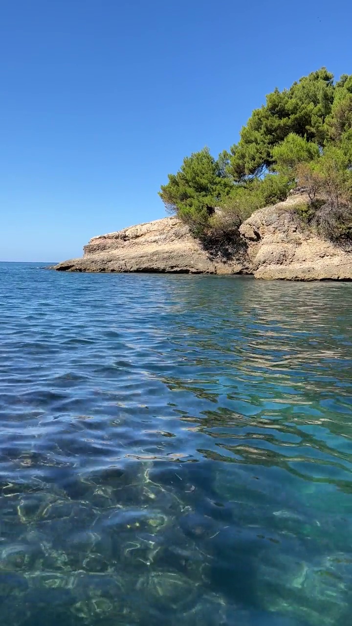 蓝色的大海和岩石在松木海岸在夏天，垂直视频。视频素材