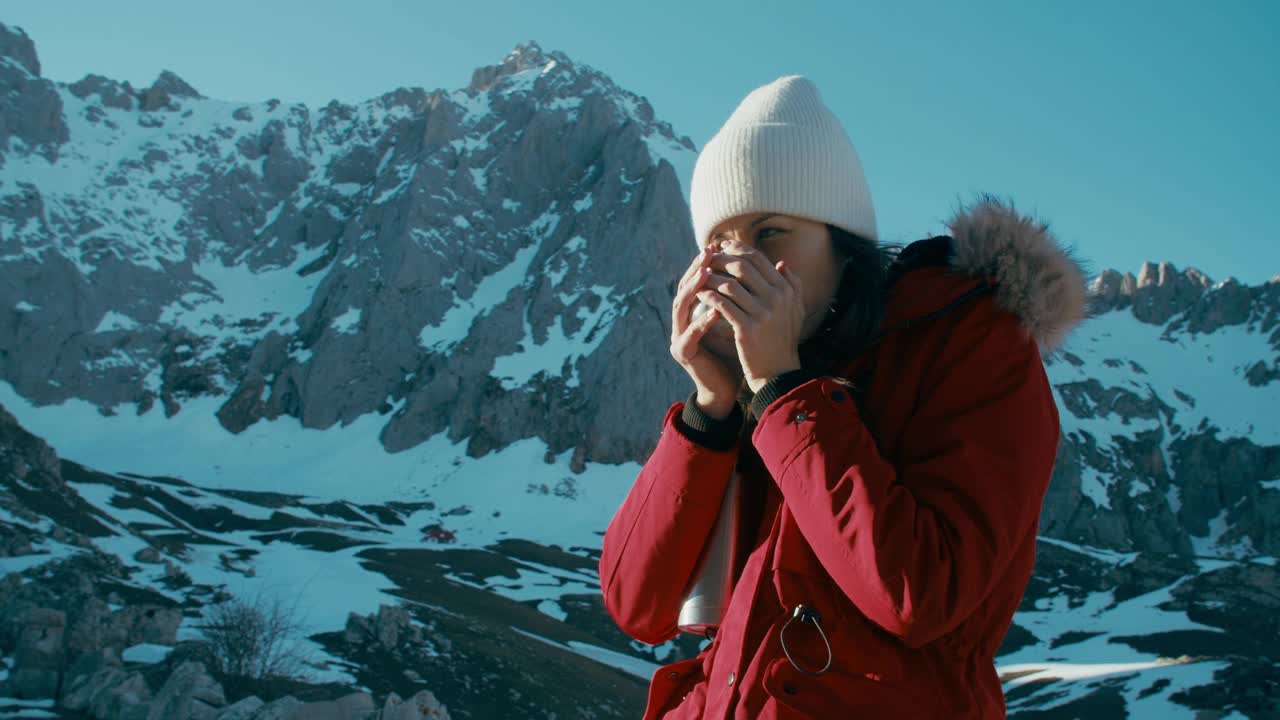 寒假徒步旅行的女游客在山顶喝热饮视频下载