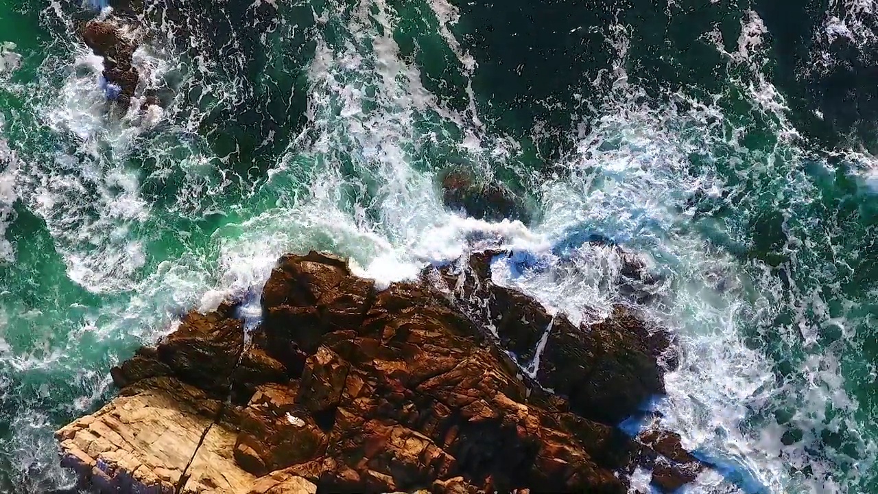 从高空向下看，海浪冲击着缅因州的岩石海岸视频素材