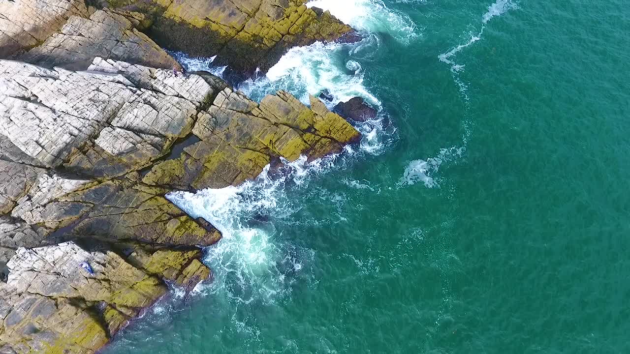 从空中俯瞰缅因州白色灯塔附近的岩石和海浪视频素材