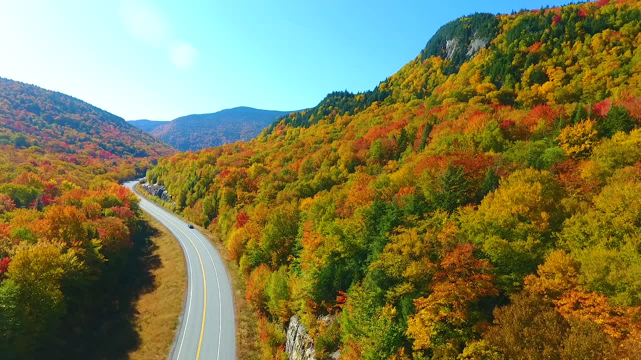 在秋叶高峰期间，从空中俯瞰穿过新罕布什尔州山脉的迷人道路视频素材