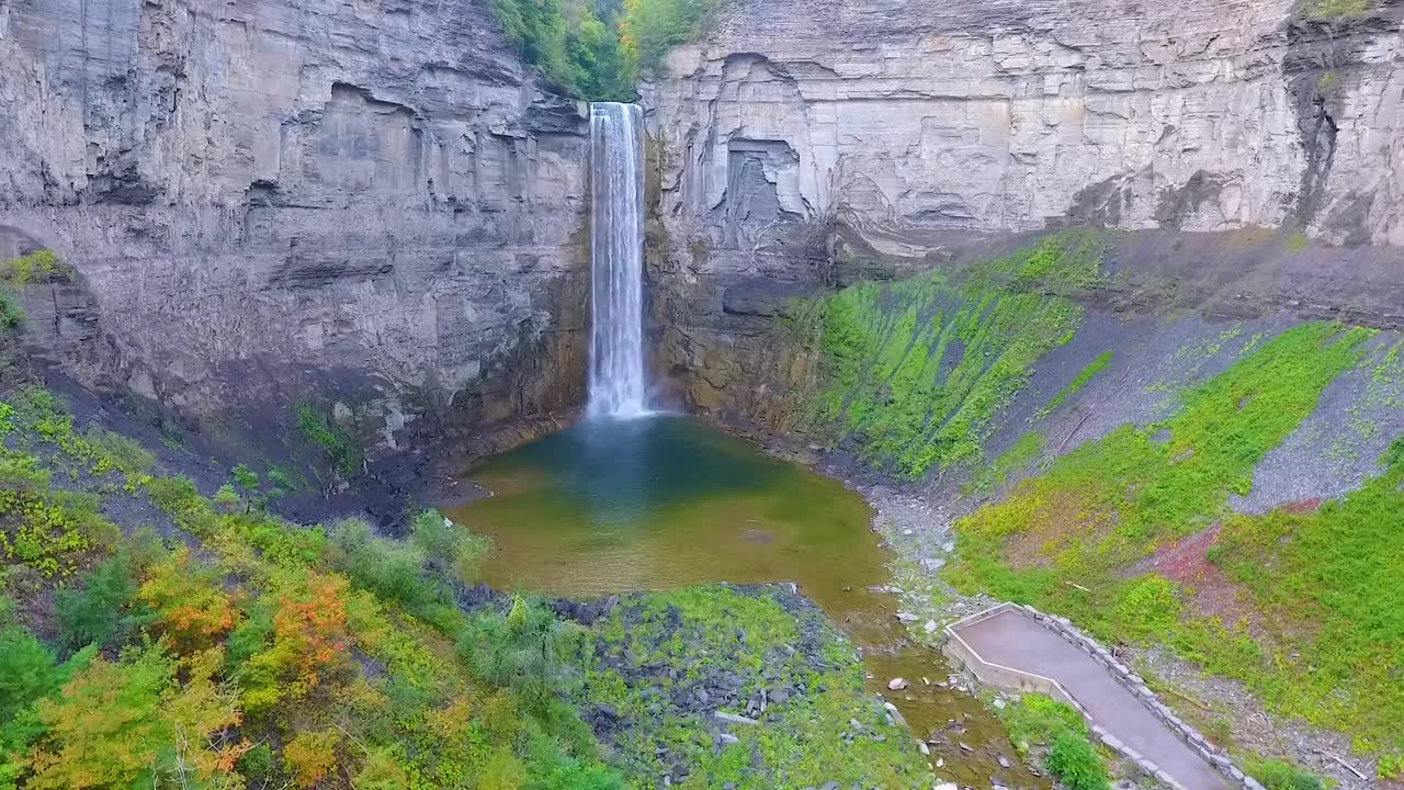 空中飞升，巨大的瀑布流入峡谷的岩石悬崖视频素材