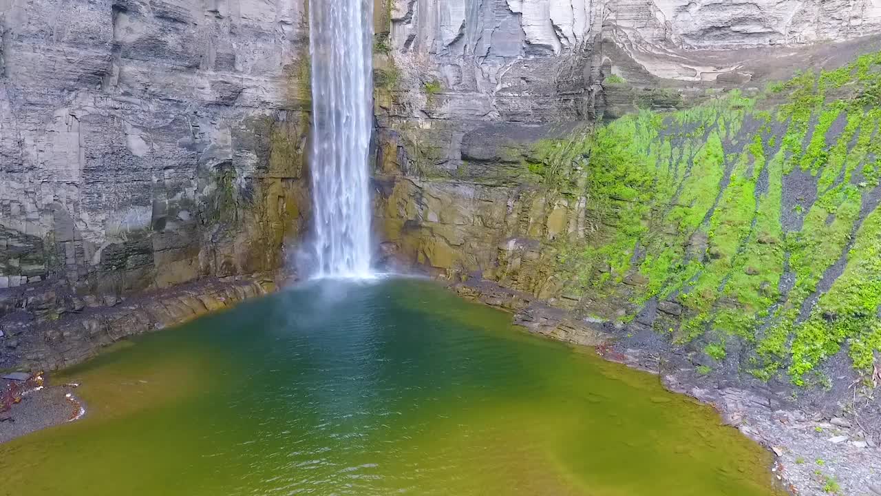 近距离的空中俯瞰，巨大的瀑布流入有岩石悬崖的大峡谷视频素材