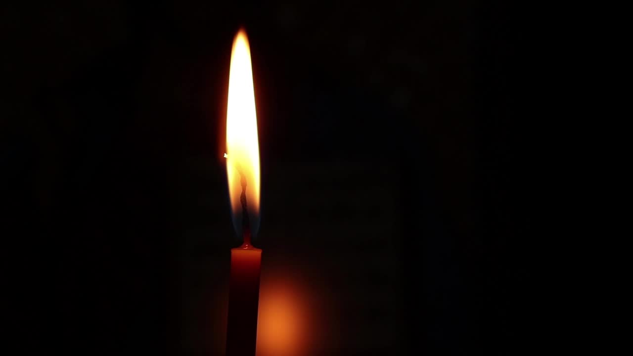 在黑暗的特写镜头中一支燃烧着的蜡烛的火焰视频素材