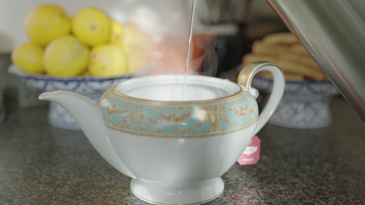 用慢动作把热茶倒进茶杯和茶壶里视频素材