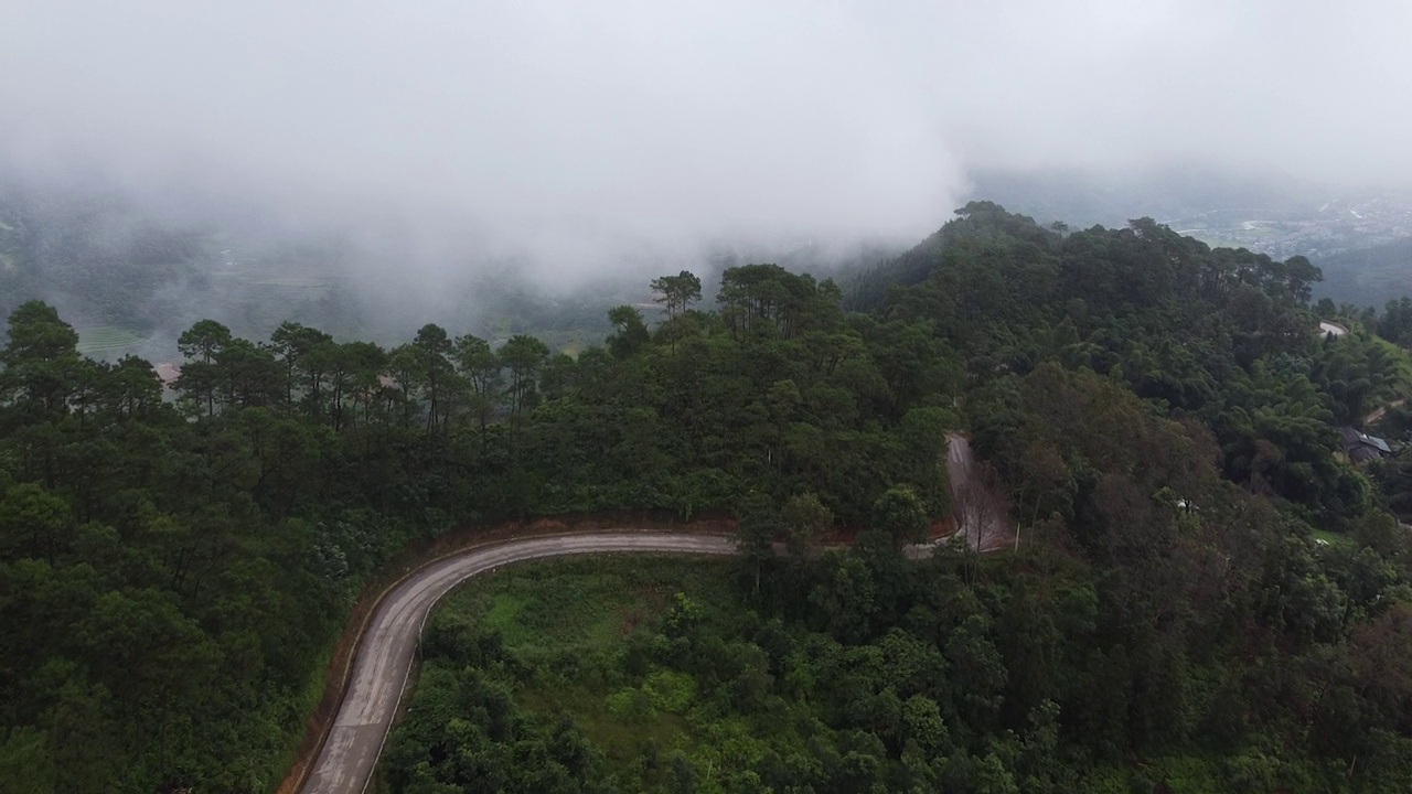 空中4K:飞越山路和有雾云的温室，太阳在雾中升起视频素材