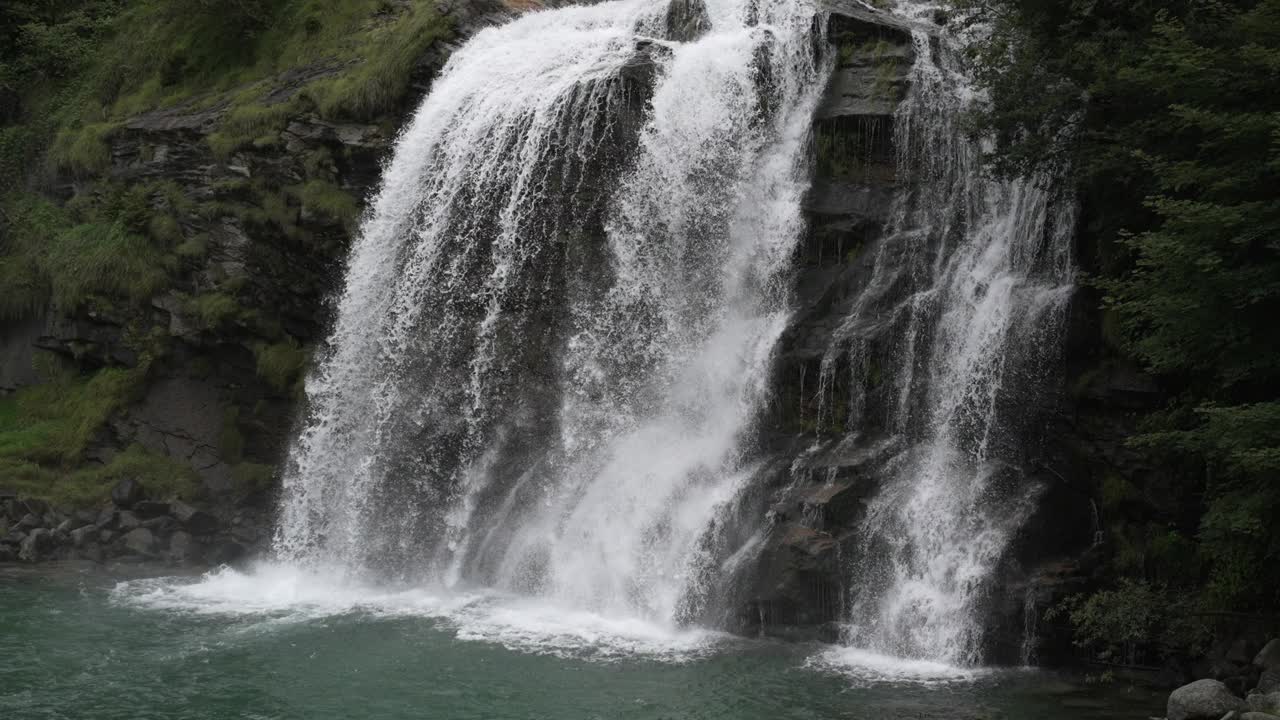 空中无人机看到的瀑布(cascata piumogna)被郁郁葱葱的绿树包围视频素材