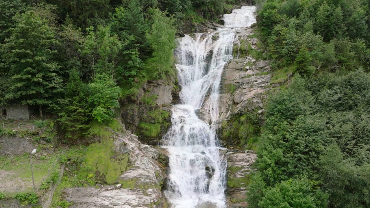 空中无人机看到的瀑布(cascata piumogna)被郁郁葱葱的绿树包围视频素材