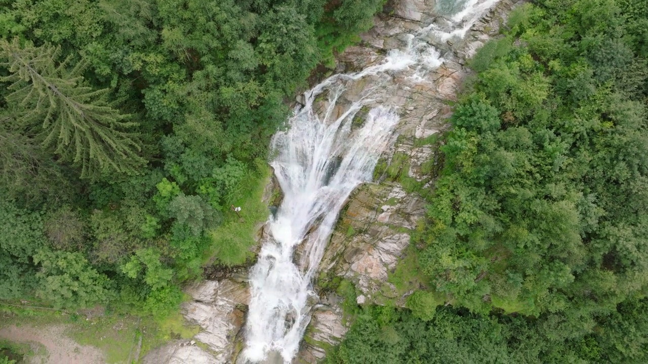 空中无人机看到的瀑布(cascata piumogna)被郁郁葱葱的绿树包围视频素材