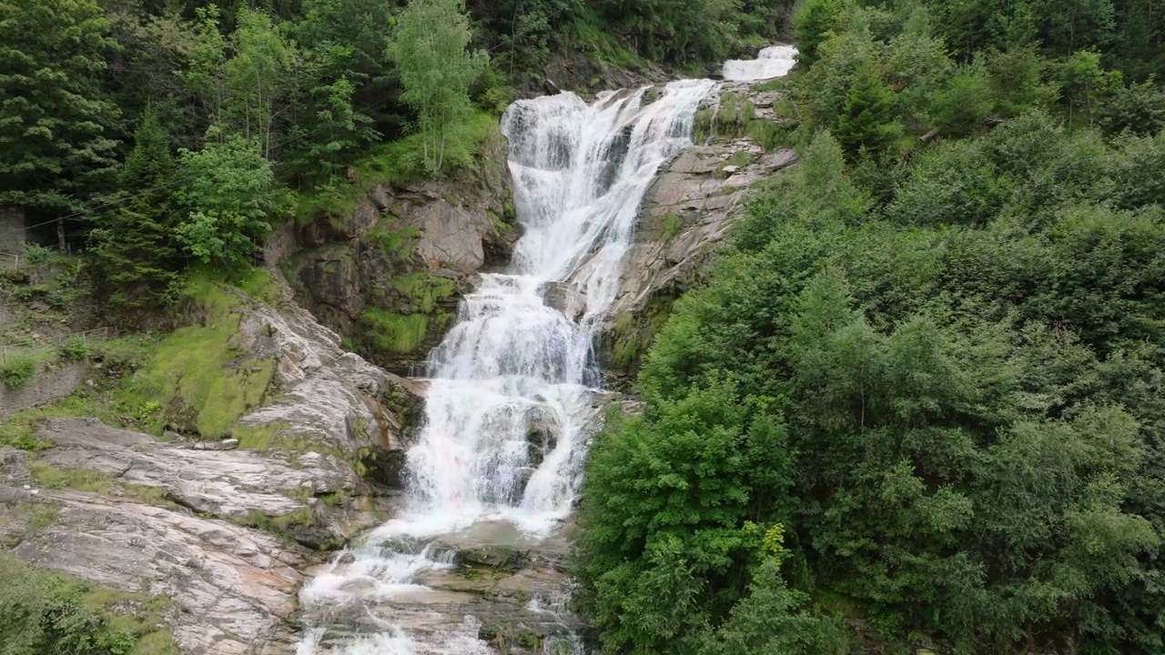 空中无人机看到的瀑布(cascata piumogna)被郁郁葱葱的绿树包围视频素材