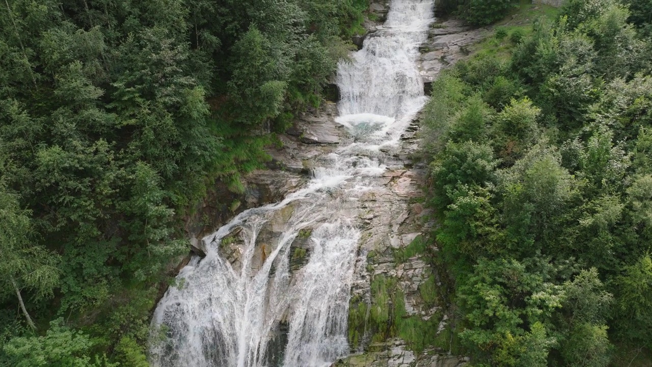 空中无人机看到的瀑布(cascata piumogna)被郁郁葱葱的绿树包围视频素材