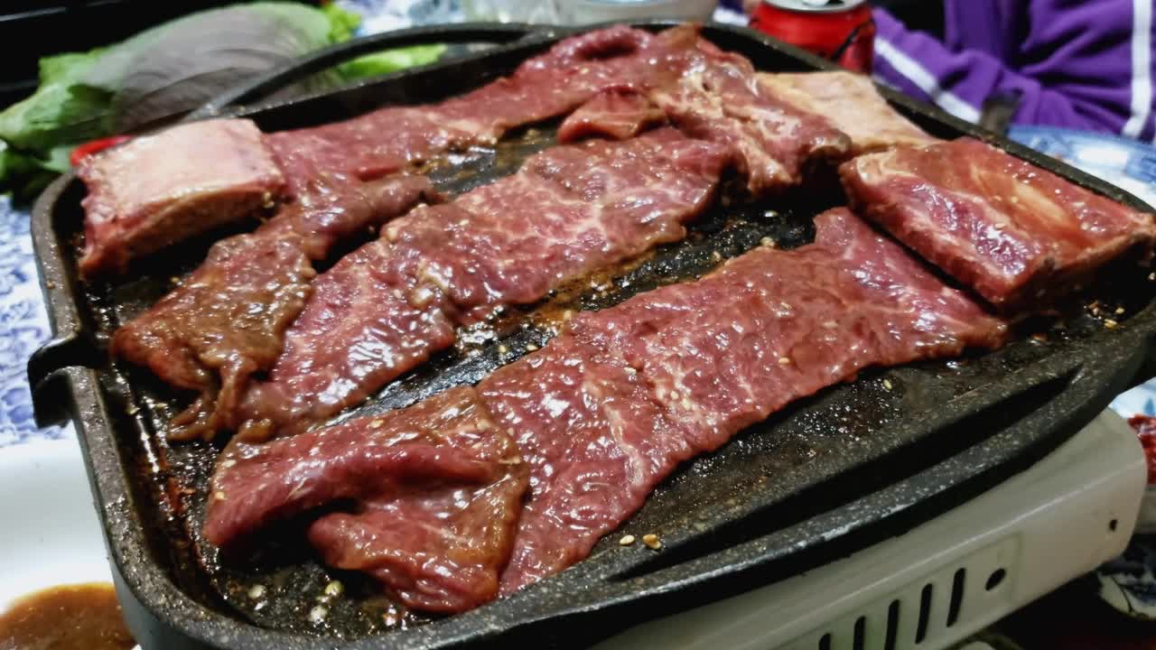 韩式烤牛肉排骨(Kalbi或Galbi)在热盘子上滋滋作响视频素材