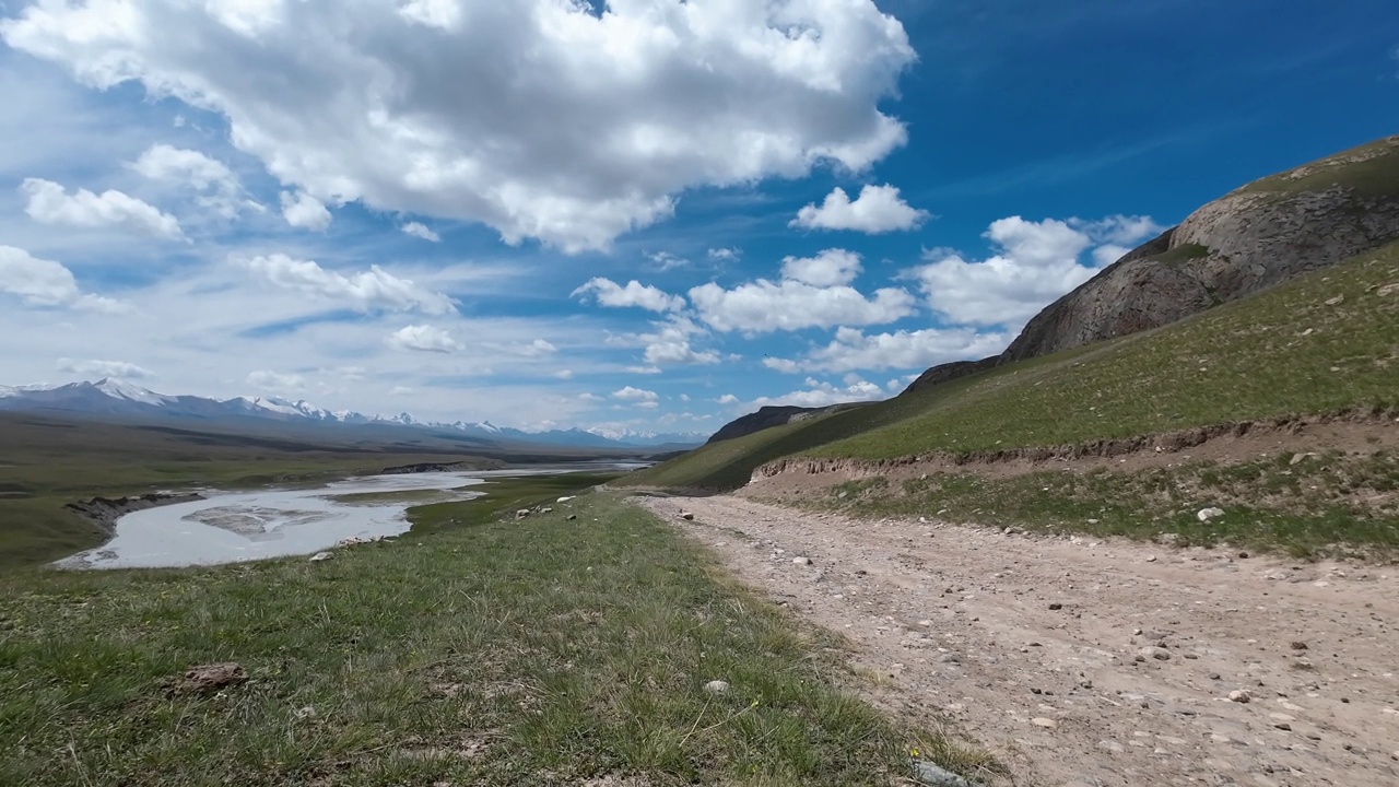 沿着Saryjaz山河的泥泞岩石道路上的云层。汽车的观点视频下载