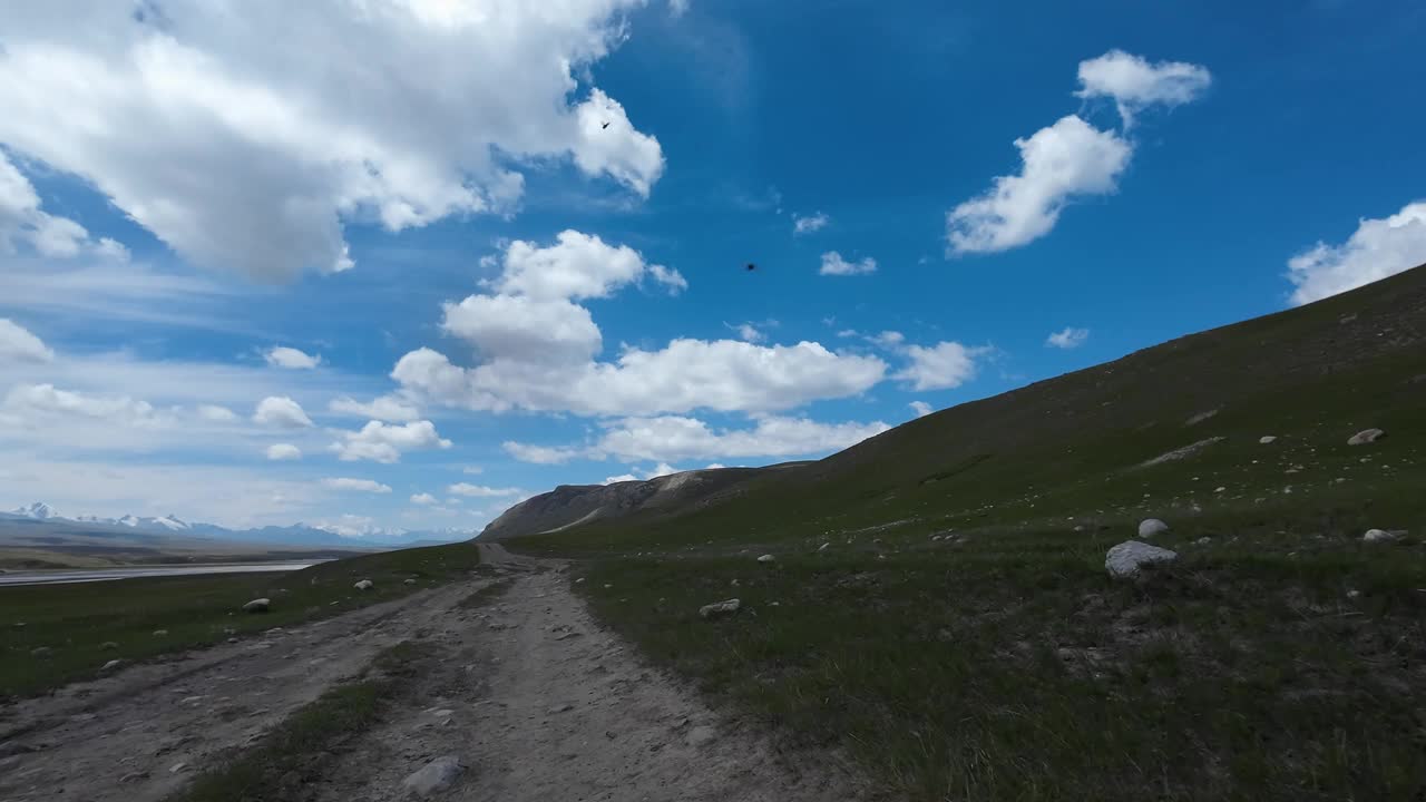 沿着山河行驶在土石路上。汽车的观点视频下载