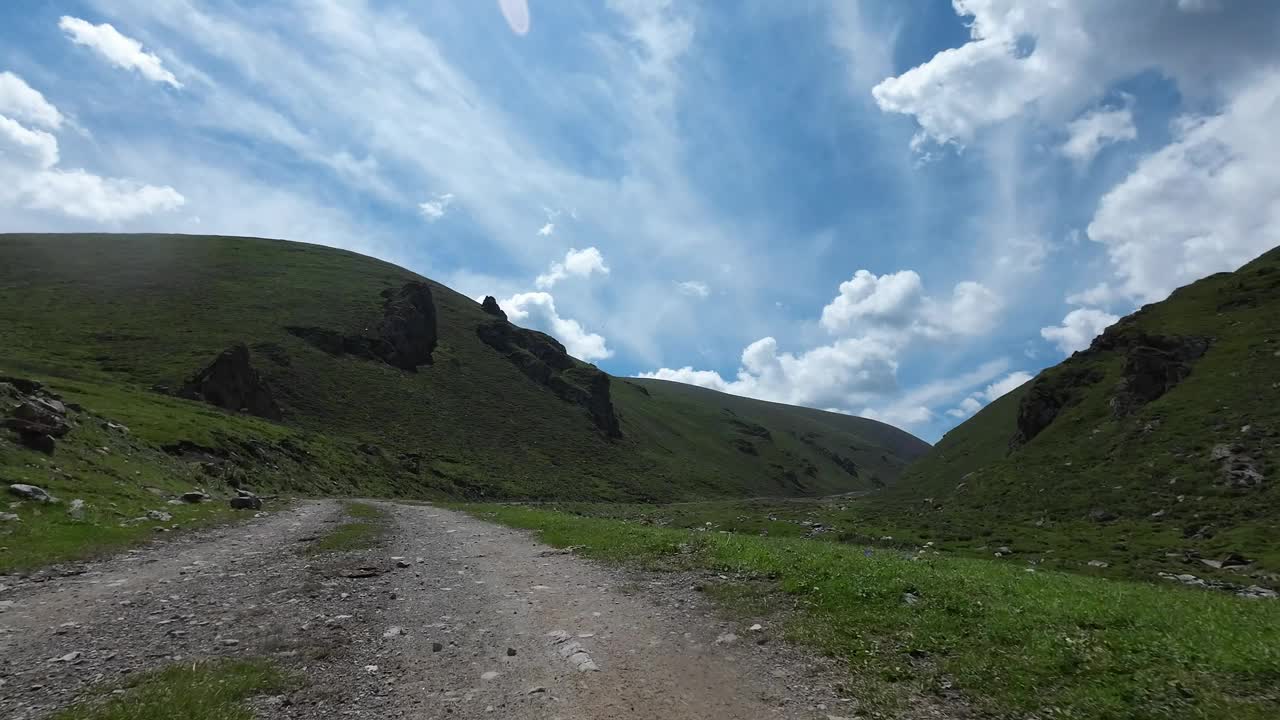 行驶在岩石路上穿过狭窄的绿色峡谷。汽车的观点视频下载